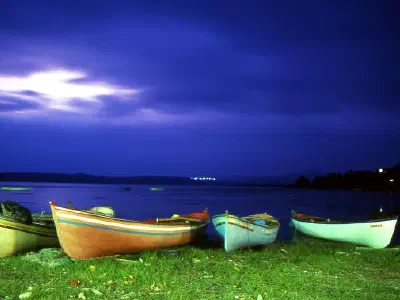 There are very beautiful, colorful boats at the lake.