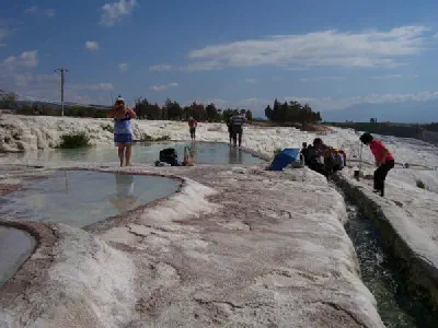 You should walk with naked foot on travertine. You can go in to small pools.